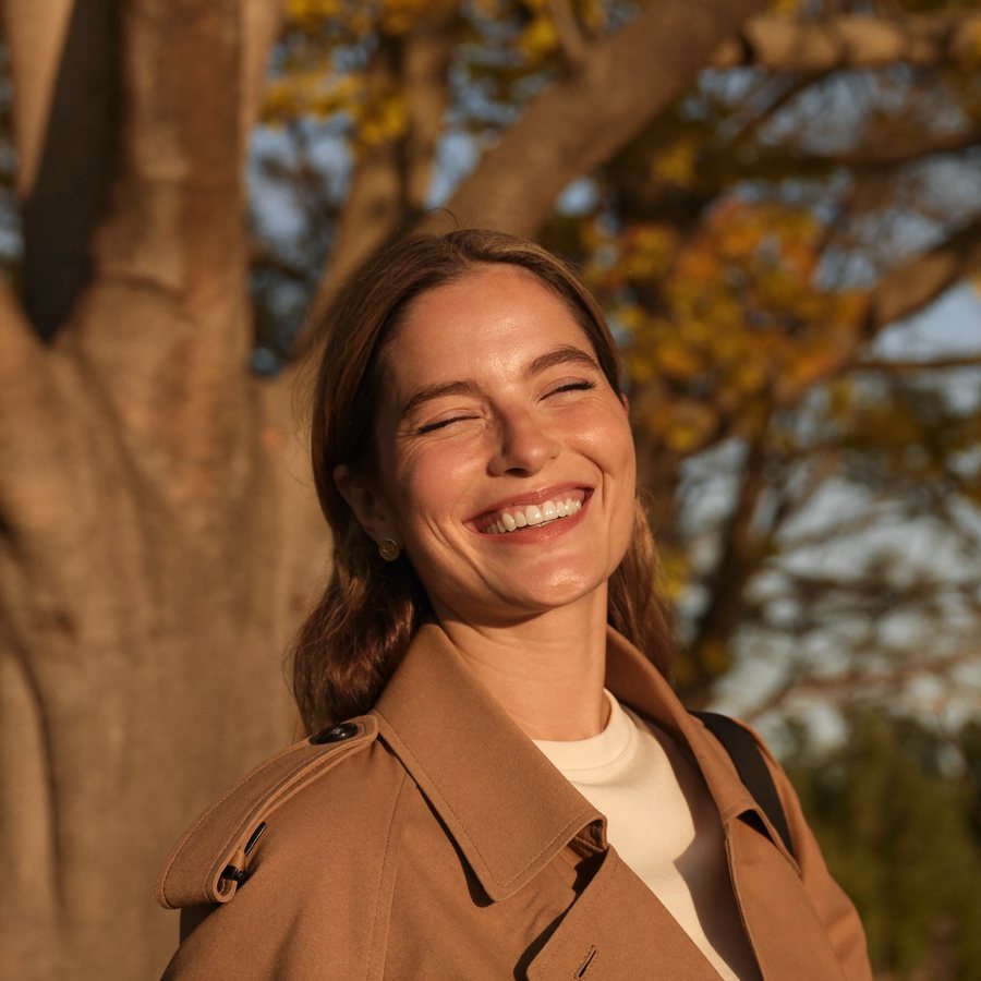 Woman with clear, even-toned skin in autumn sun, TRIBRID laser special