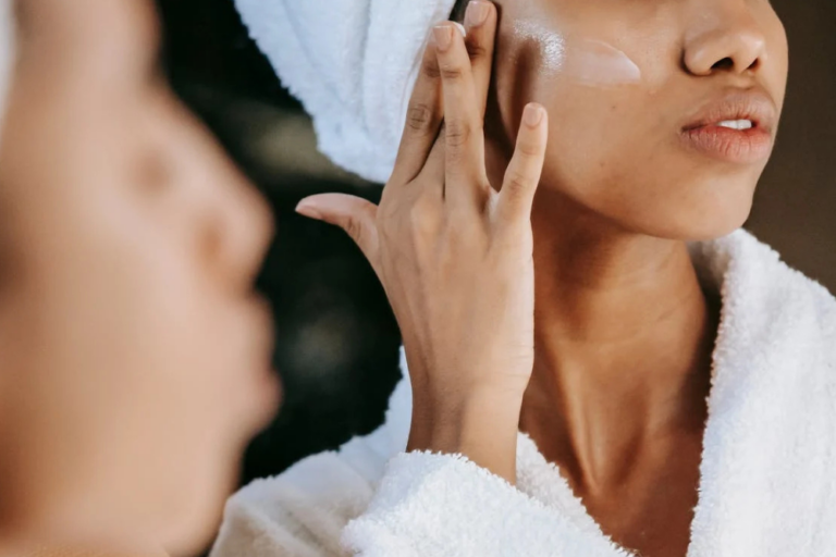 Woman applying skincare routine at home, focusing on hydration and anti-aging treatment